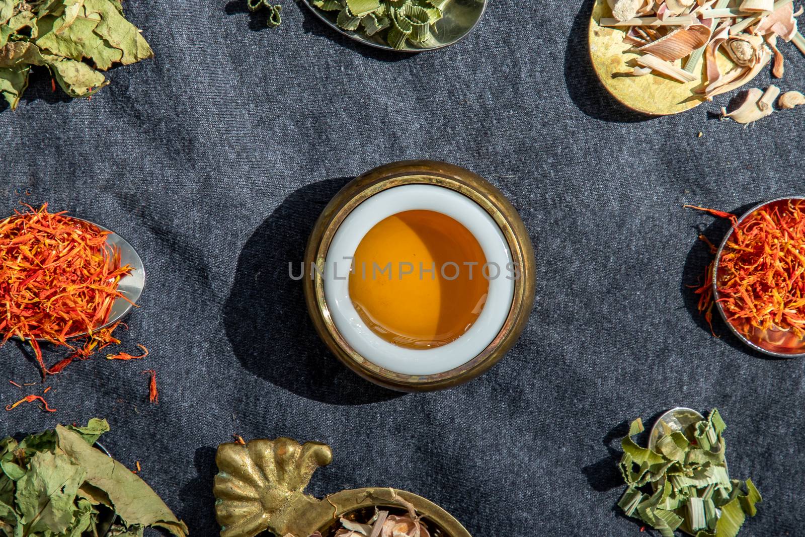 Various teas and dried herbs assortment on spoons in rustic style with honey on balck background. Organic herbal, Selective focus.