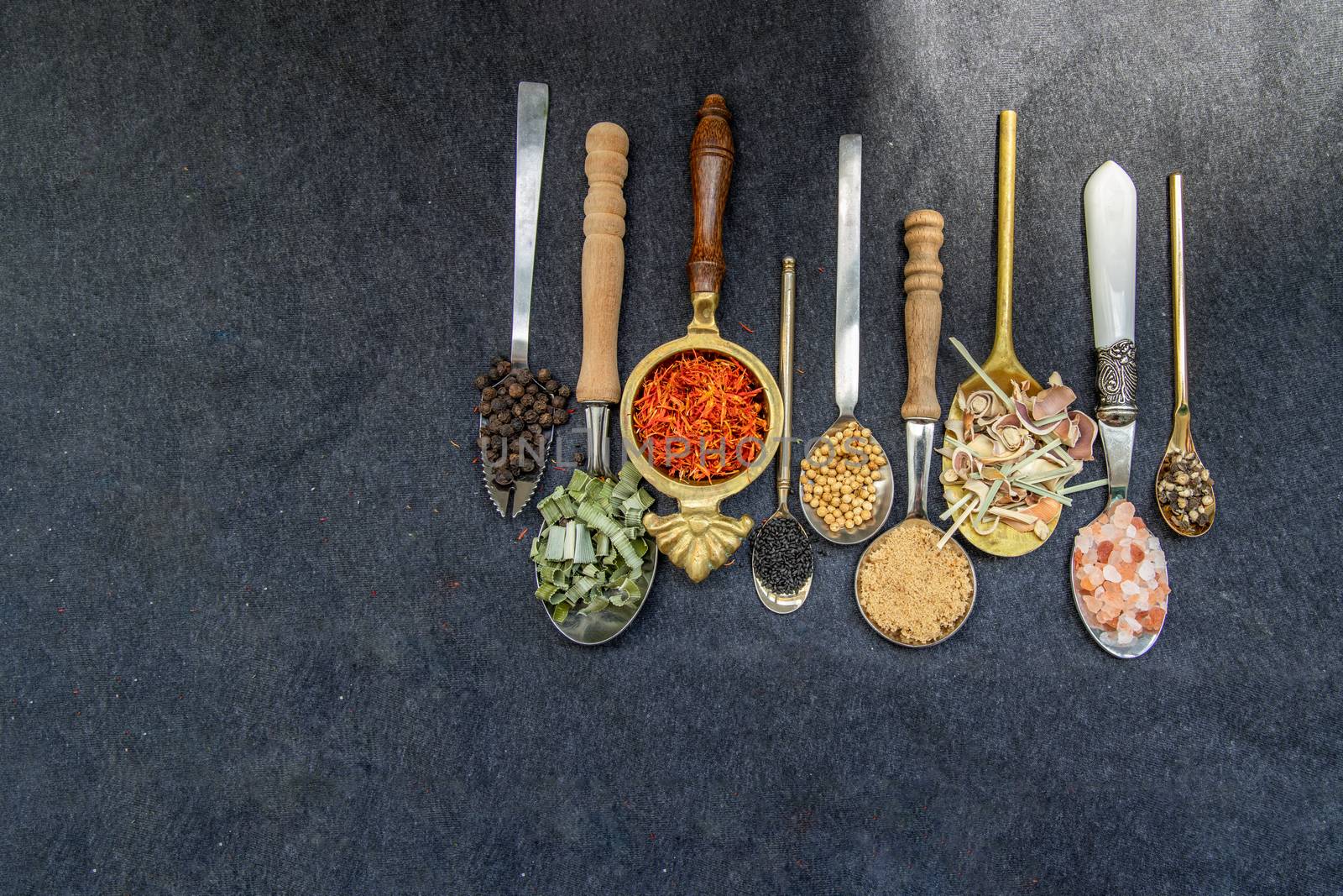 Various teas and dried herbs assortment on spoons in rustic style on balck background. Organic herbal, Selective focus, Copy space.