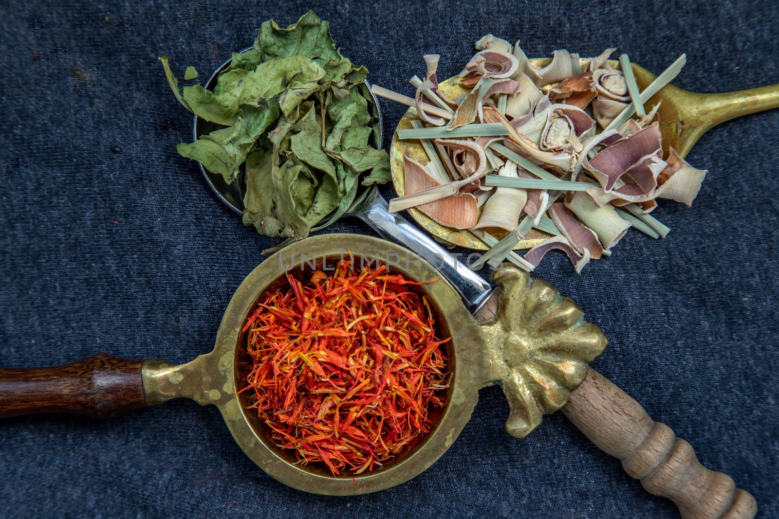 Wonderful Thai herbal tea with Dried lemongrass herb, indian marsh fleabane and safflower on spoons. Selective focus.