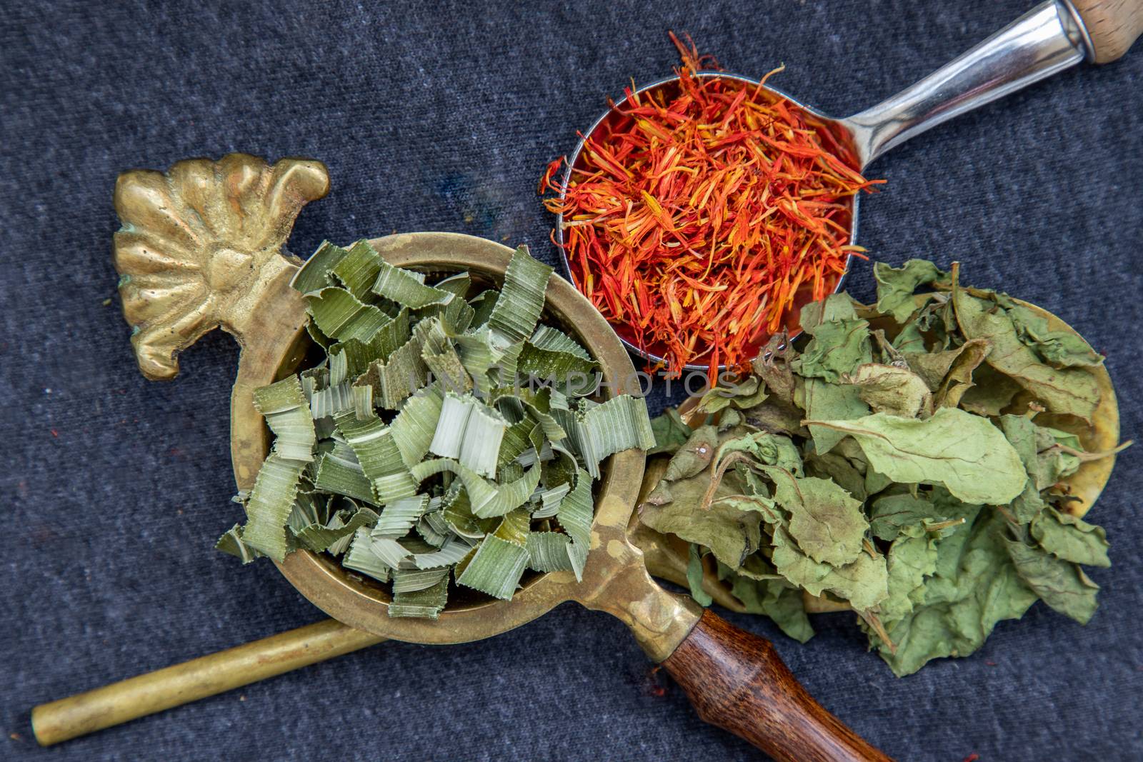 Wonderful Thai herbal tea with Dried pandan herb, indian marsh fleabane and safflower on spoons. Selective focus.