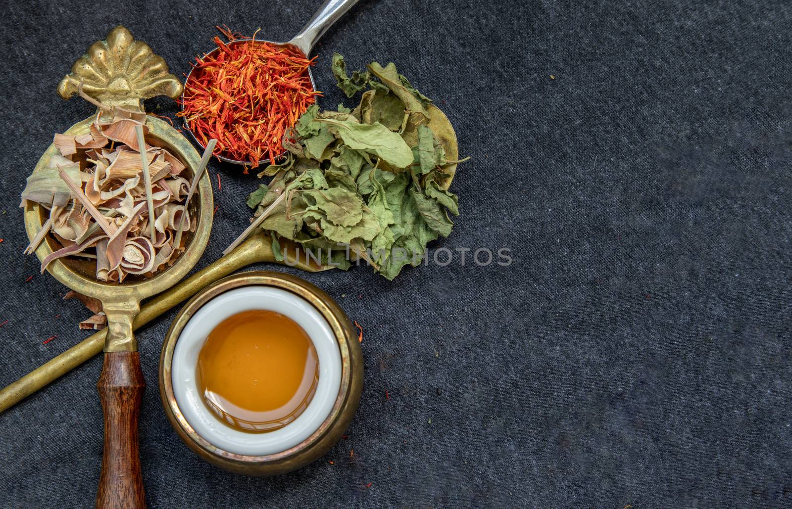 Wonderful Thai herbal tea with Dried lemongrass herb, indian marsh fleabane and safflower with honey on spoons. Selective focus.