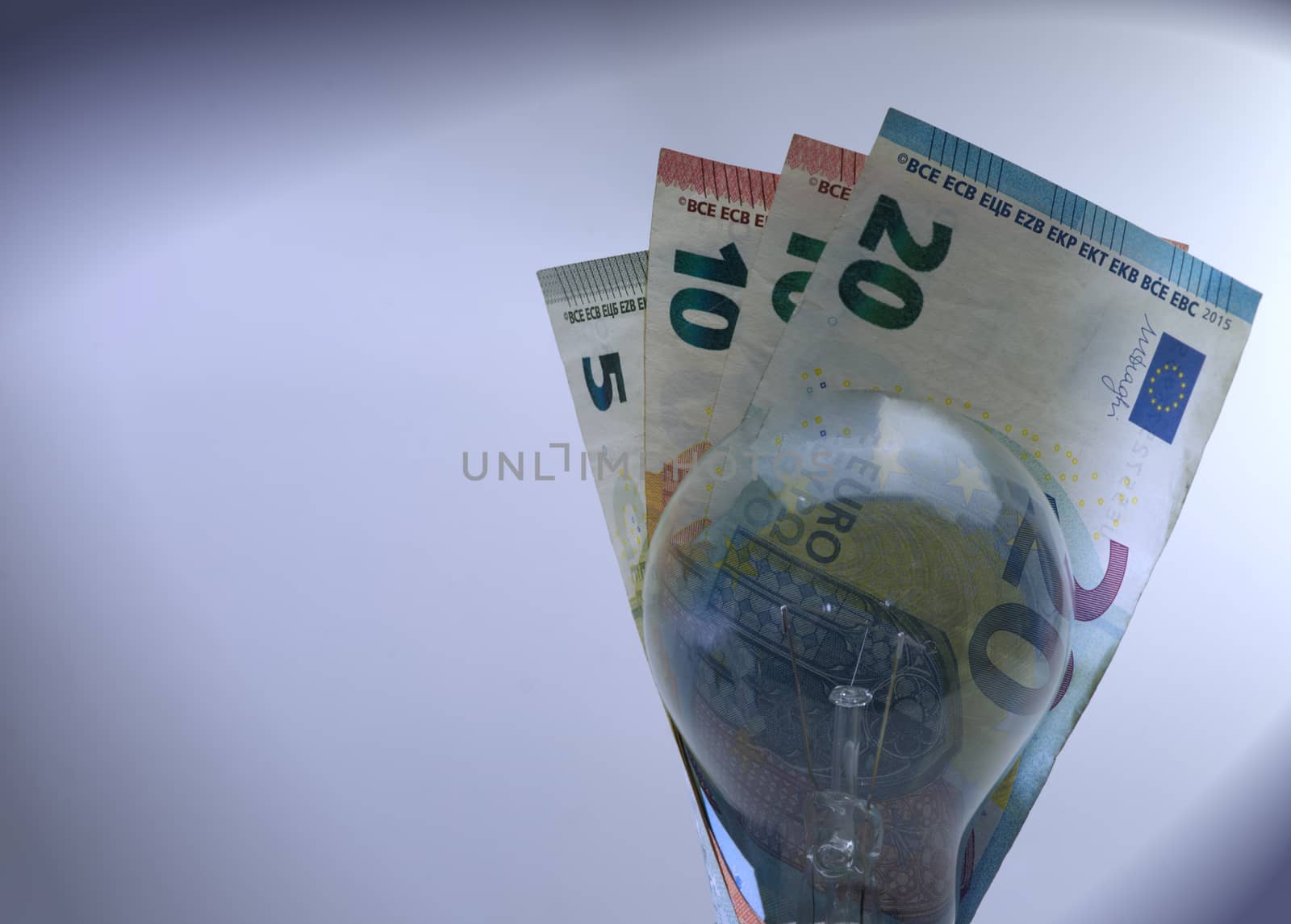 The abstract bulb with euro banknotes and copying areas.