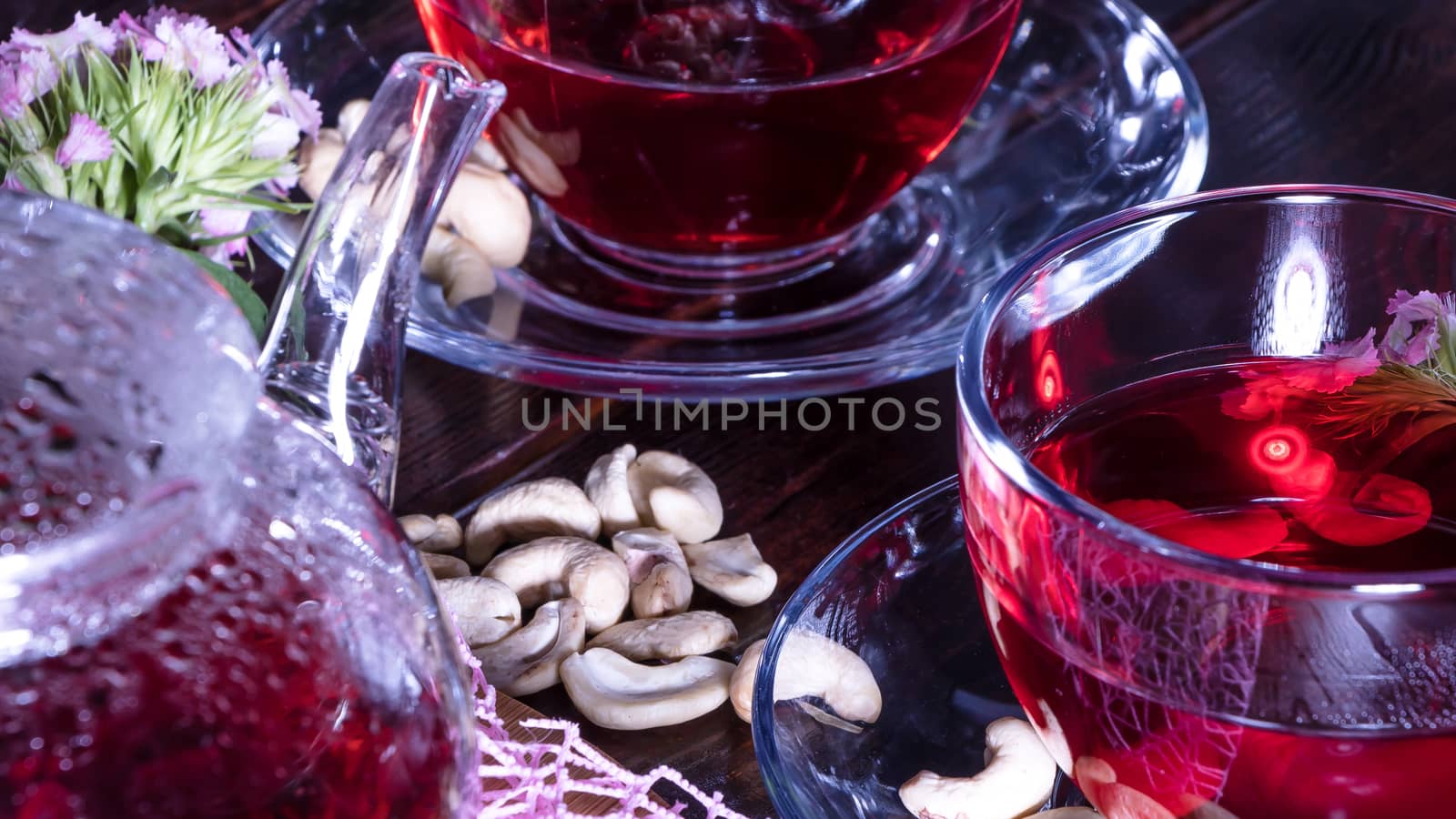 Hibiscus Red tea mug with carnation flowers close-up horizontal photo.English tea tradition.Medicinal therapy based on medicinal herbs and decoctions.Spicy herbs and medicinal broths.Elegant mugs