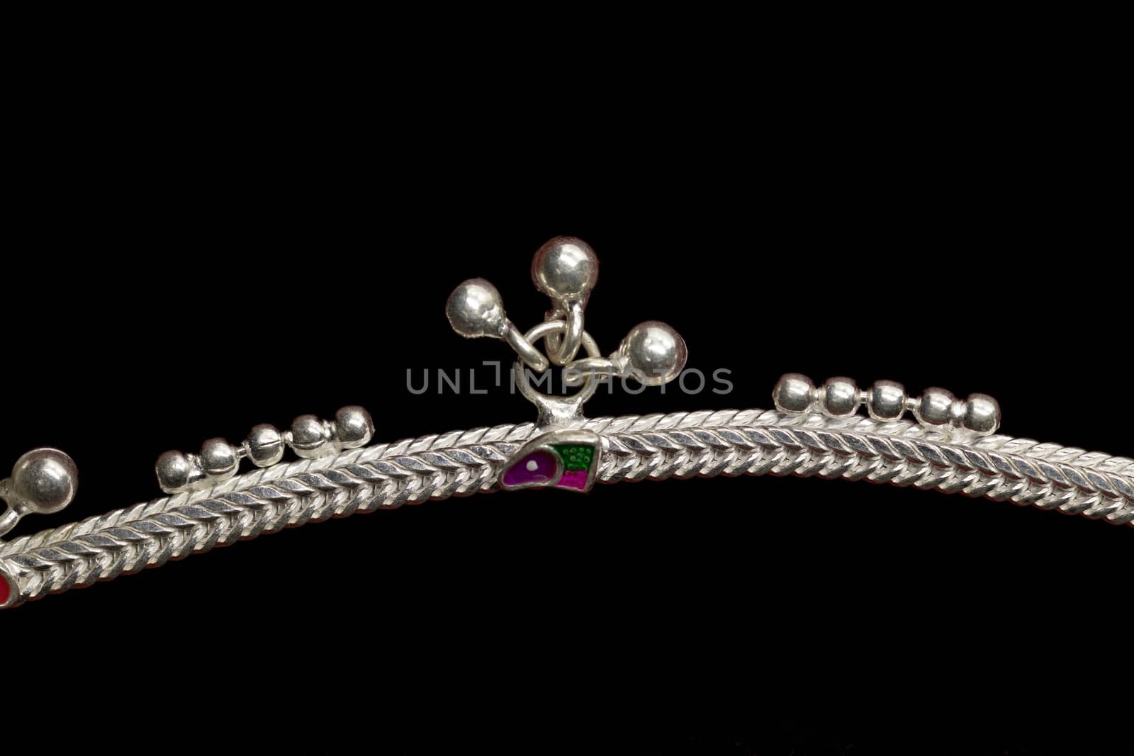Curly silver anklet for catalogue design book on black background