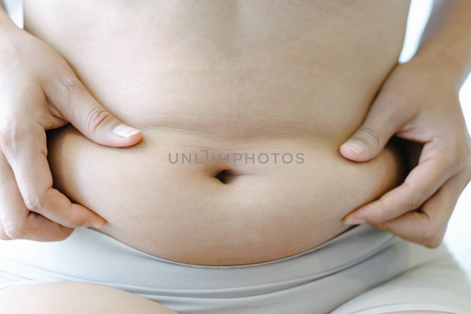 Closeup hand holding abdominal surface woman fat, healthy care a by pt.pongsak@gmail.com