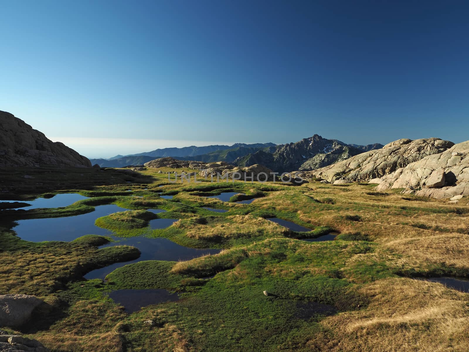 beautiful mountain scenery with blue lagoons in the meadow