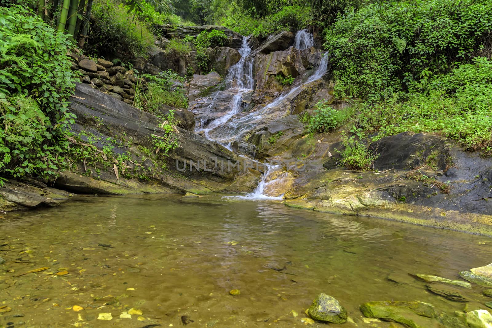 Waterfall cascade in jungle tropical rainforest rock mountain river motion blur
