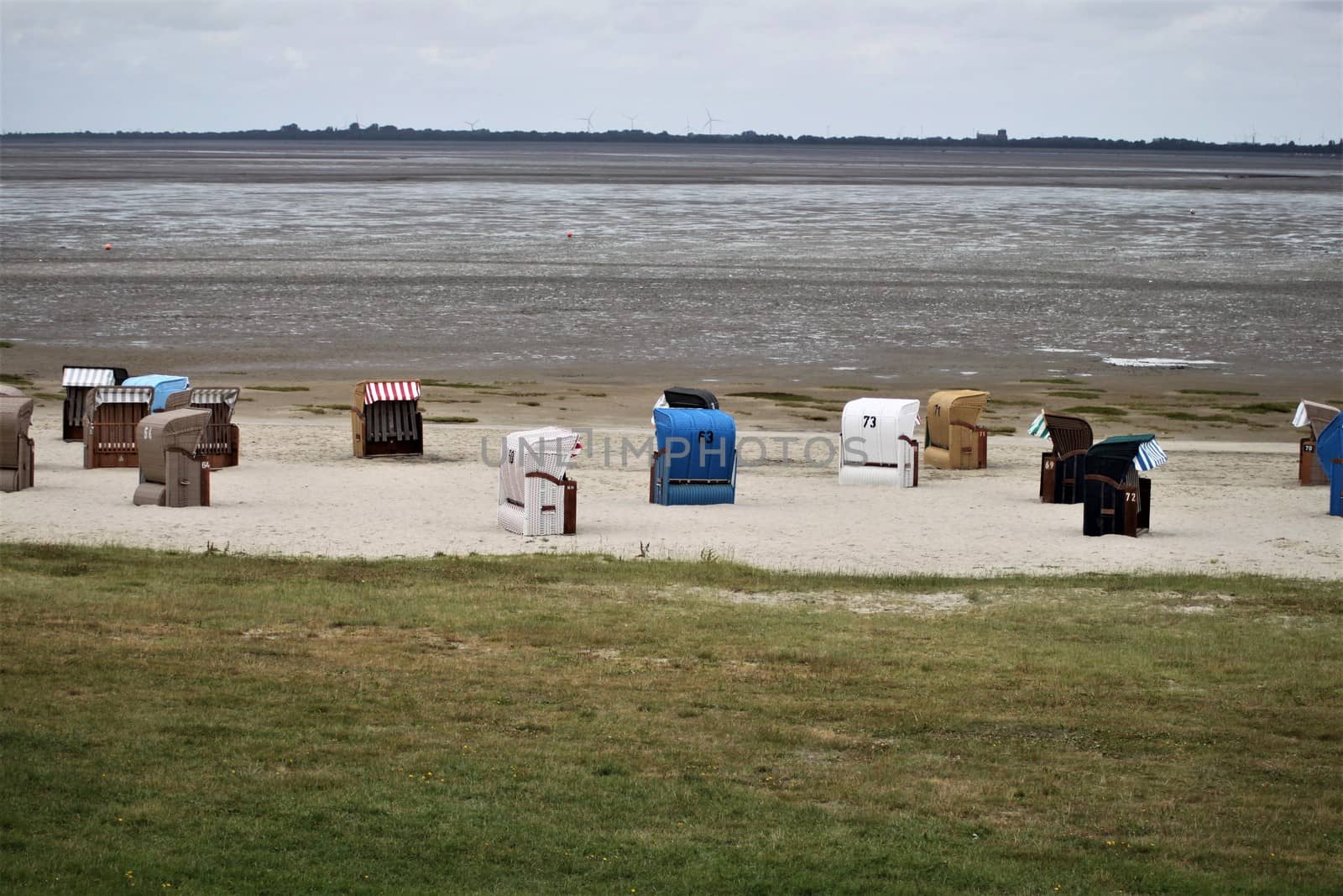 Some beach chairs on the Norht Sea durind low tide on the watt