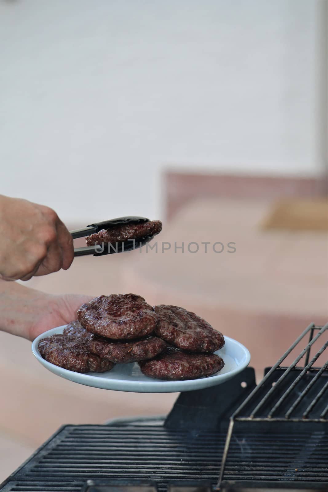 Minced steaks are placed on a plate from the grill by Luise123