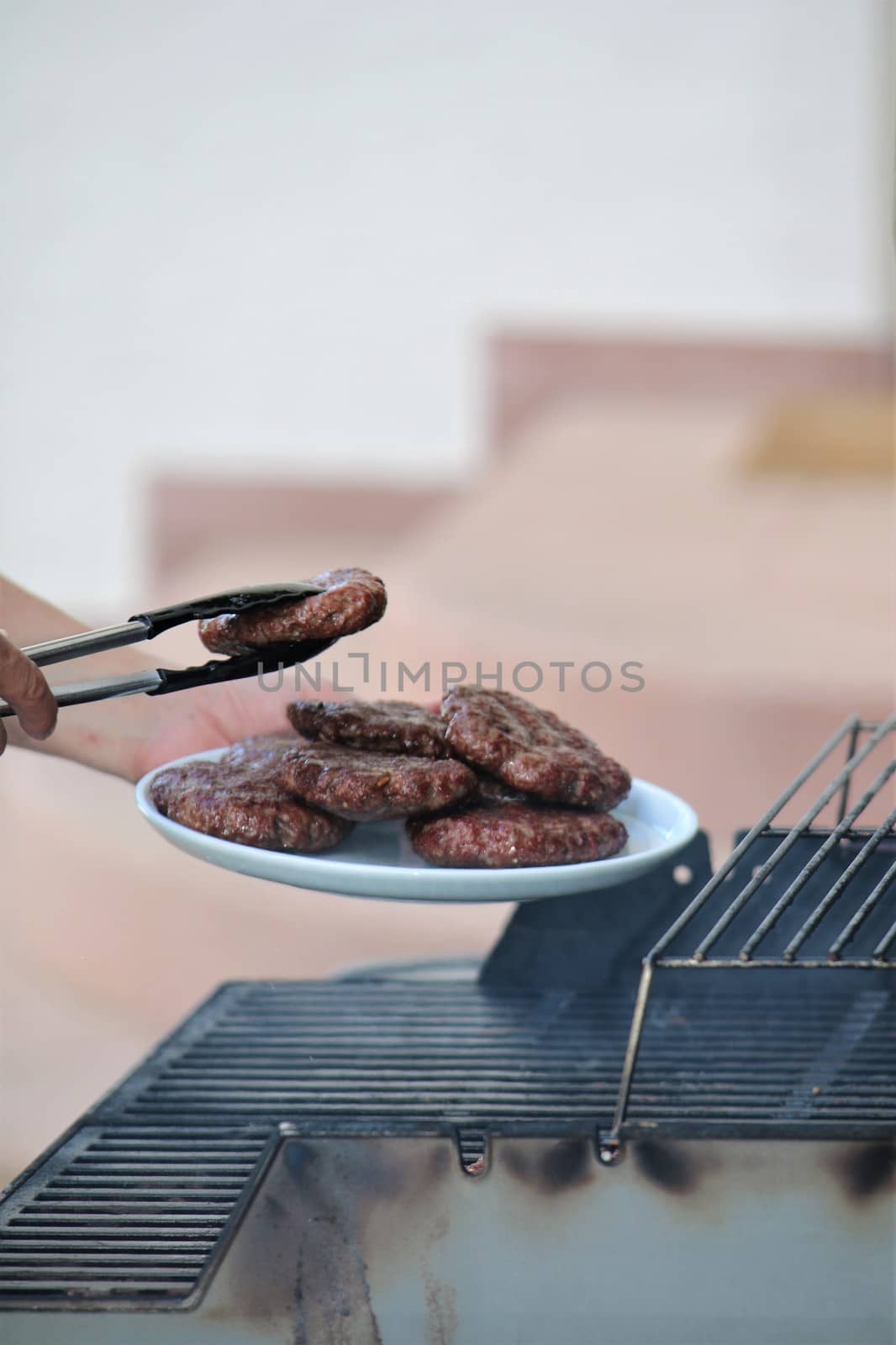 Minced steaks are placed on a plate from the grill by Luise123