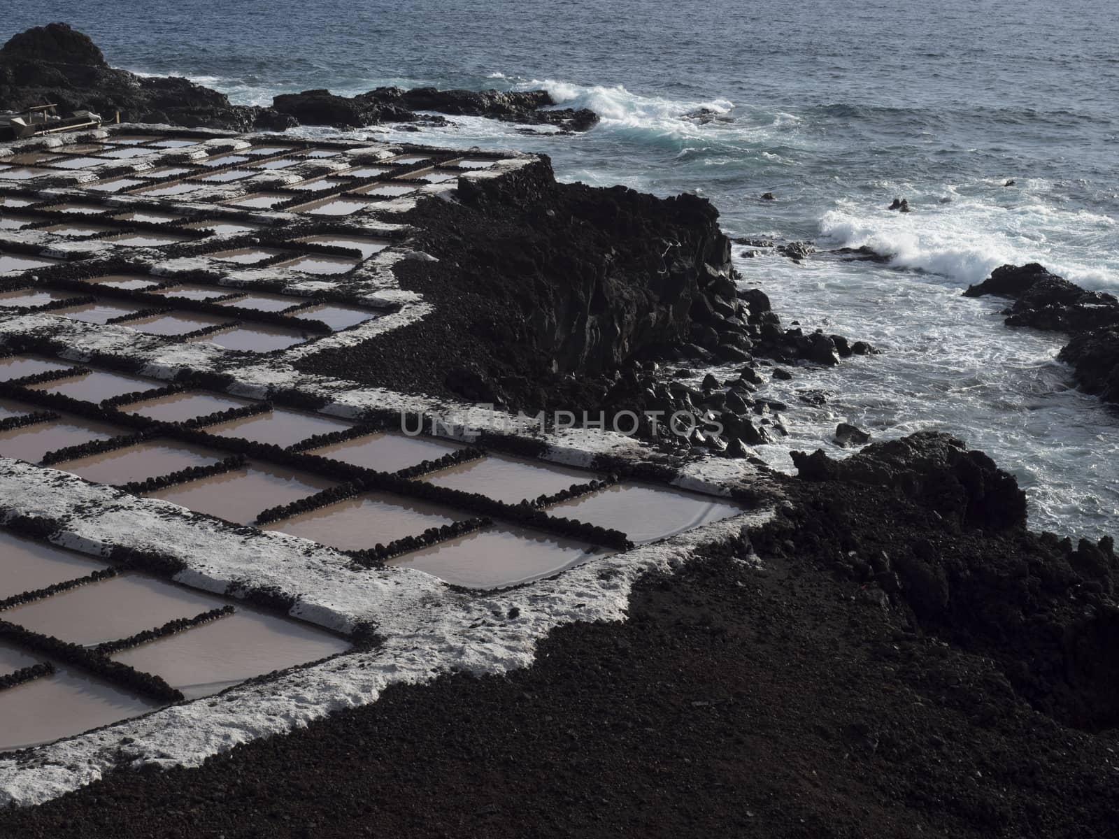 View of Fuencaliente salinas or saltworks and volcanic rock field and ocean coast. La Palma, Canary Islands. Ocean, blue sky wh