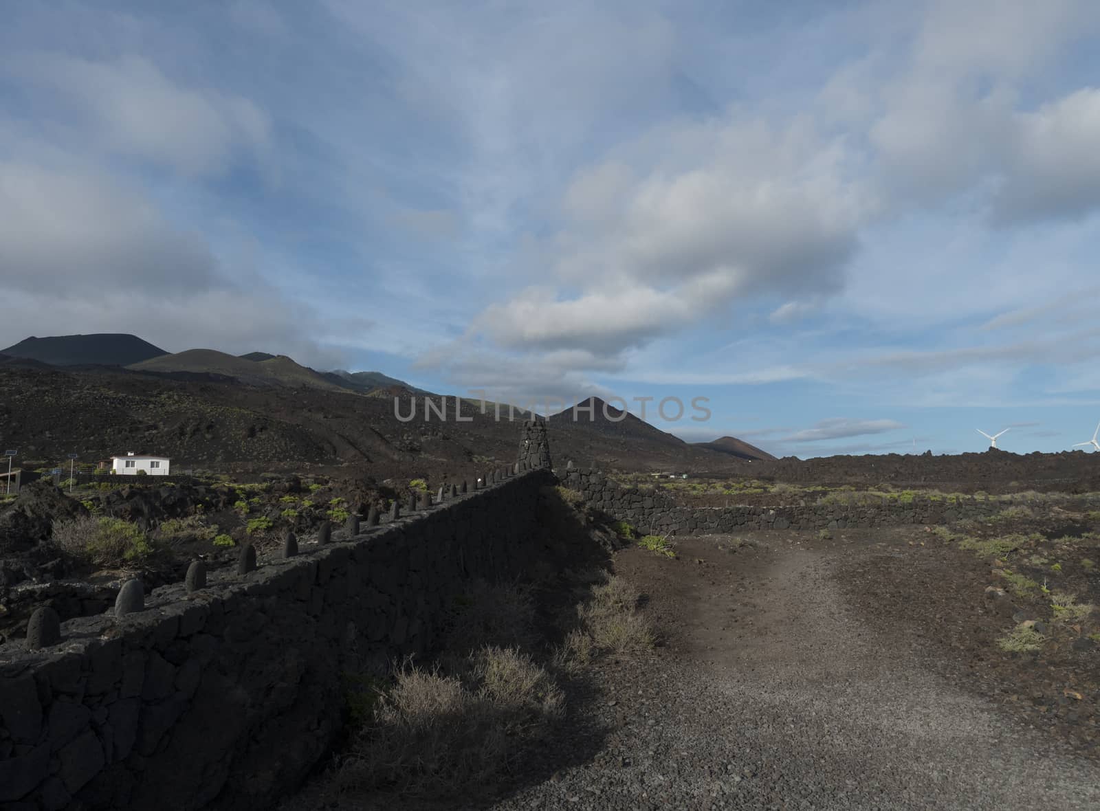 Volcanic landscape at Fuencaliente salinas near Los Canarios with lava rock wall. La Palma, Canary Islands, blue sky white clouds