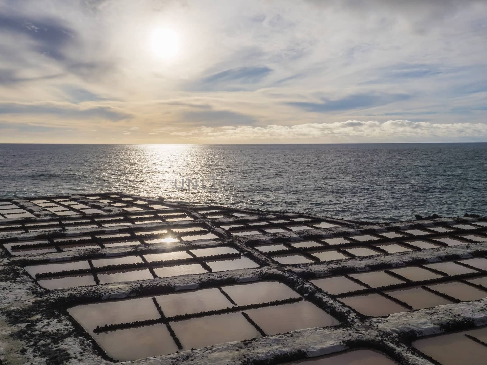 View of Fuencaliente salinas or saltworks and volcanic rock field at atlantic ocean sea shore and sun. La Palma, Canary Islands. Ocean, blue sky white clouds