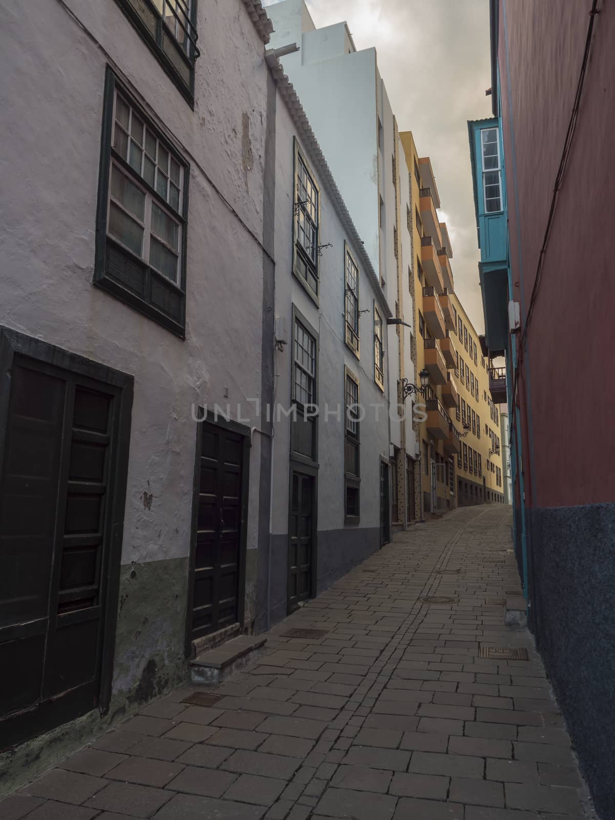 Empty narrow street at Santa Cruz de la Palma city center with colorful old traditional houses and cobble stone paving. La Palma, Canary Islands, Spain by Henkeova