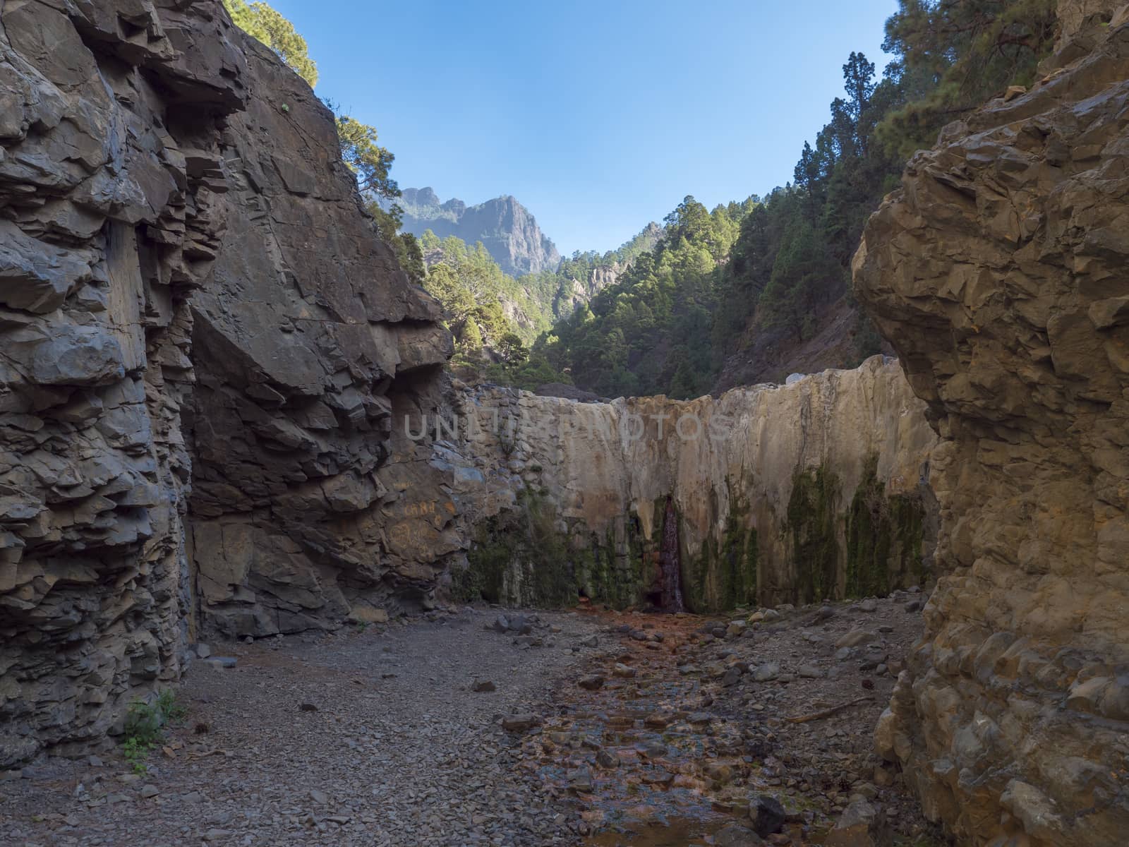 Cascada de Colores small allmost dry waterfall in a volcanic crater at Caldera de Taburiente, water stream is colorful colored by mineral water. La Palma, Canary Islands, Spain by Henkeova