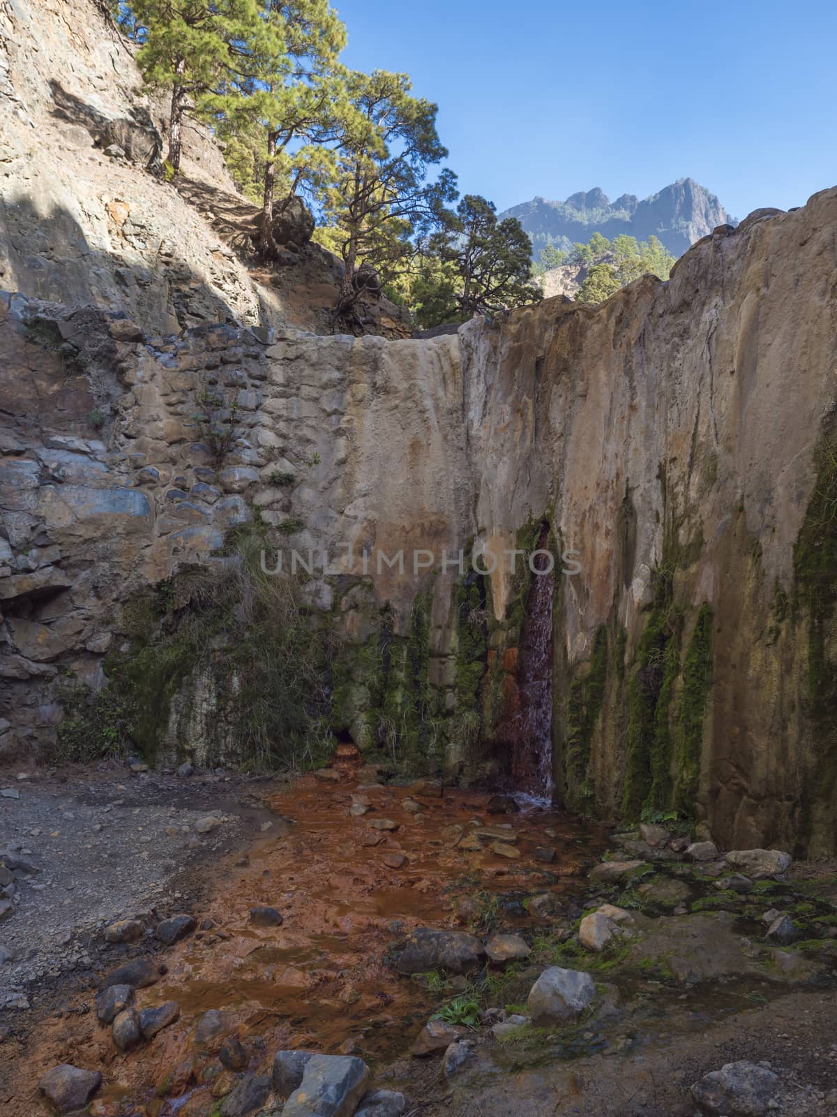 Cascada de Colores small allmost dry waterfall in a volcanic crater at Caldera de Taburiente, water stream is colorful colored by mineral water. La Palma, Canary Islands, Spain by Henkeova
