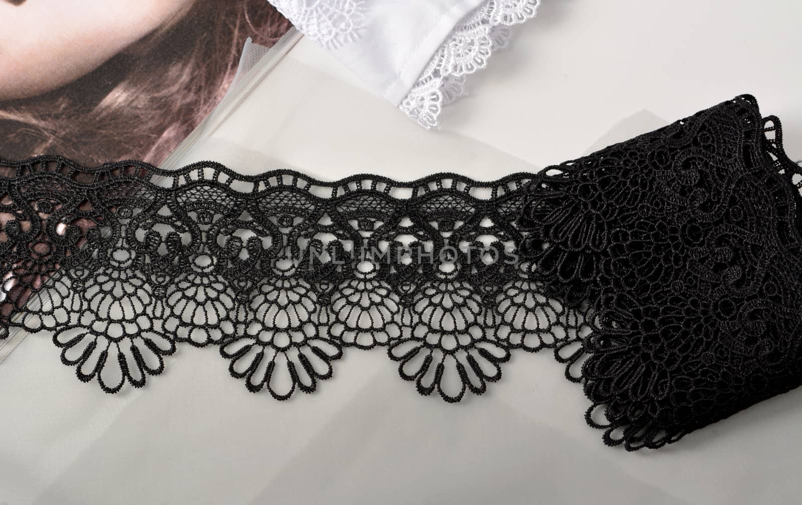 Tapes of black gentle guipure, beauty lace fabric on light background. Elastic material. Using for Atelier and needlework store.