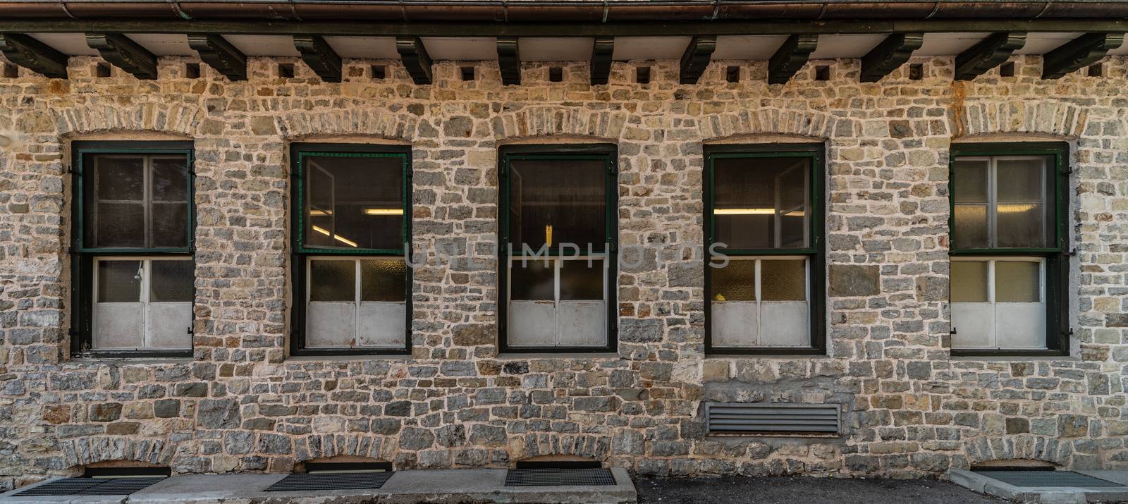 Series of windows lined up on a building of clear stones, mountain architecture