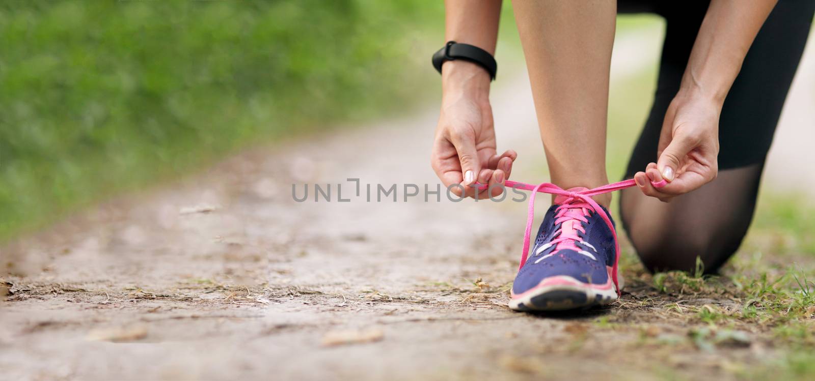 Young fitness woman tying shoelace running sneakers. Healthy fit living. by selinsmo