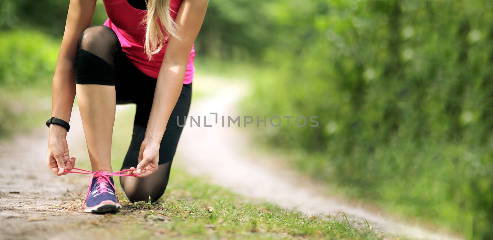 Young fitness woman tying shoelace running sneakers. Healthy fit living. by selinsmo