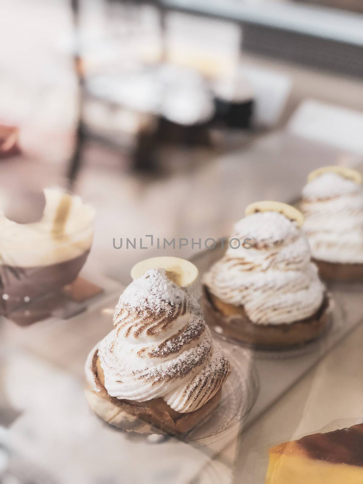Tartlet with Italian meringue and lemon cream on a wooden stand, selective focus