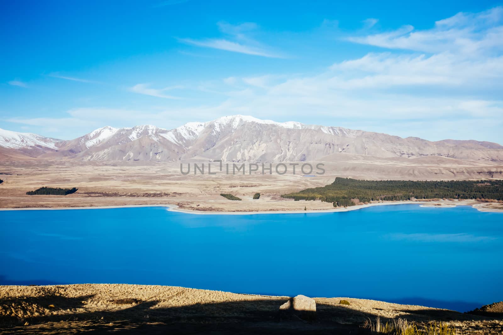 The view of the southern alps and Lake Alexandrina from Mt John Walkway and observatory area near Lake Tekapo on a clear spring evening in New Zealand