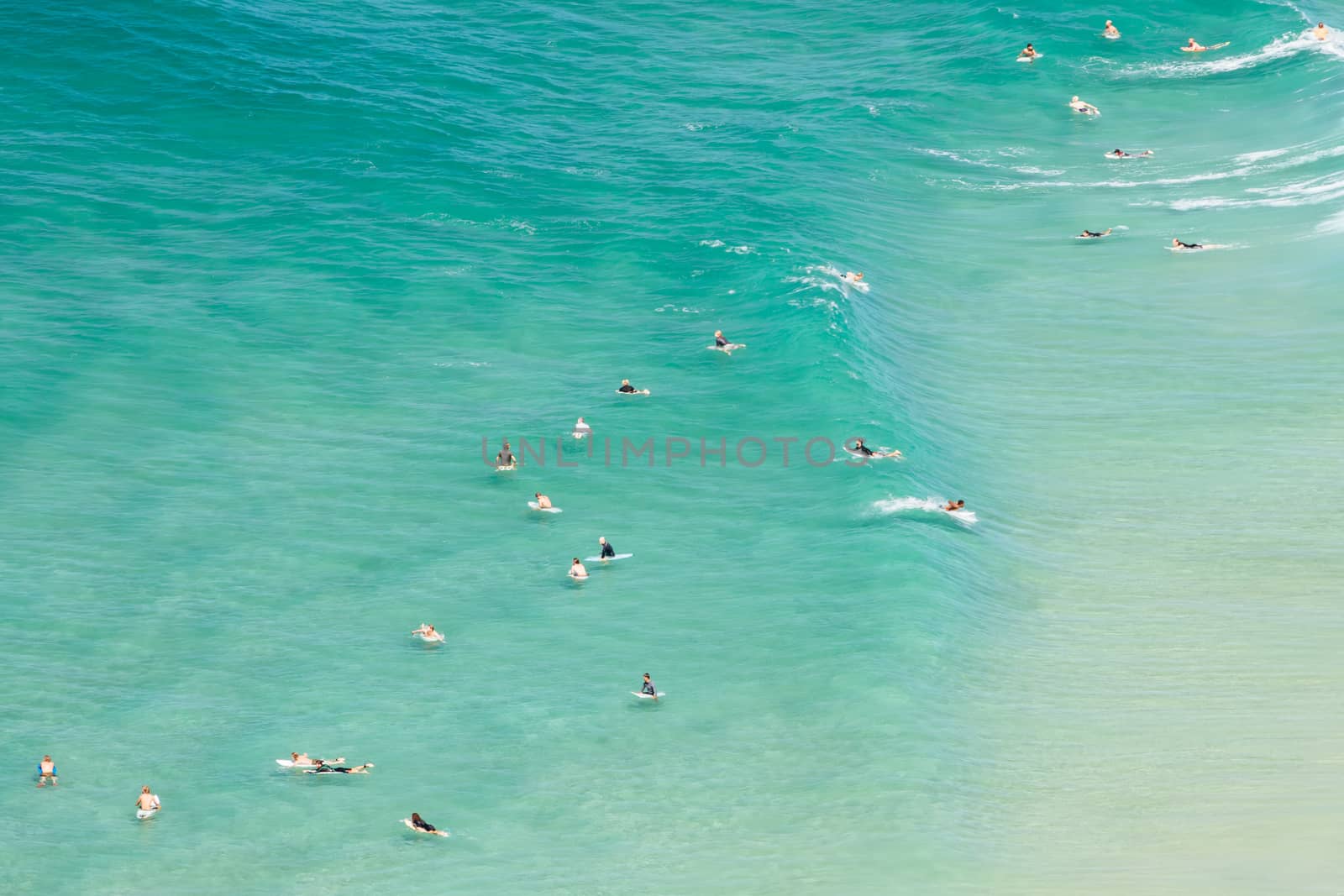 An aerial view of surfers at Tallows Beach in Byron Bay, New South Wales, Australia