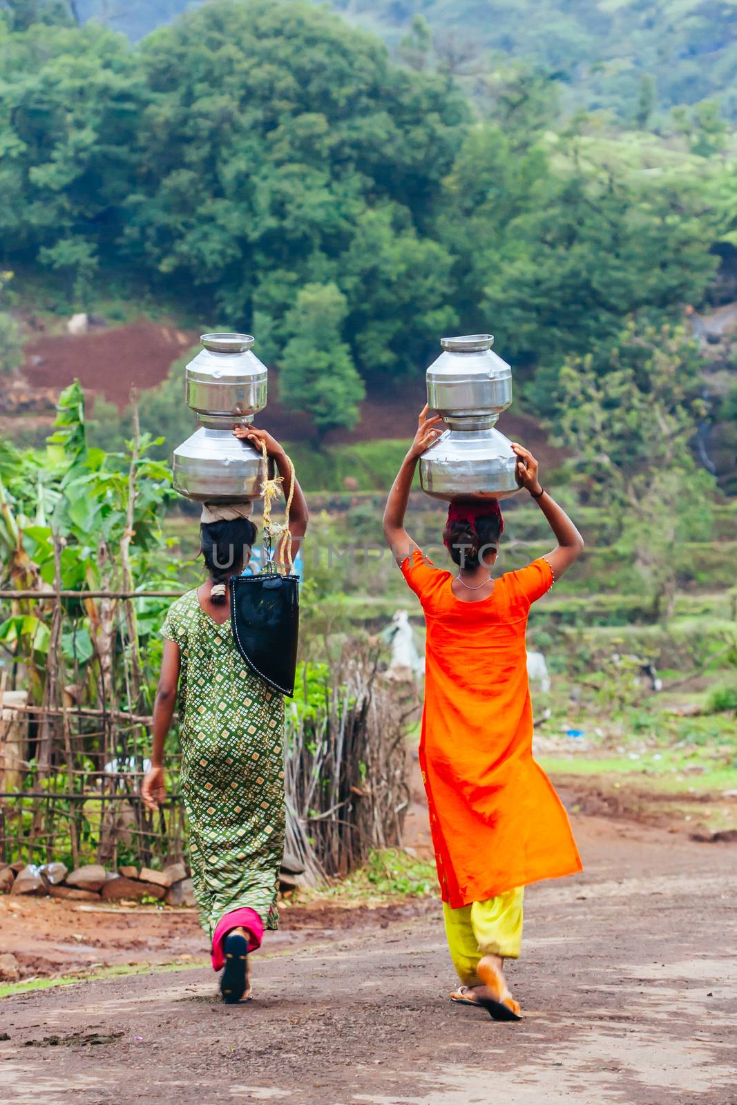 Villagers carry water on a moist summer's day near Ratangad fort in Maharashtra in India