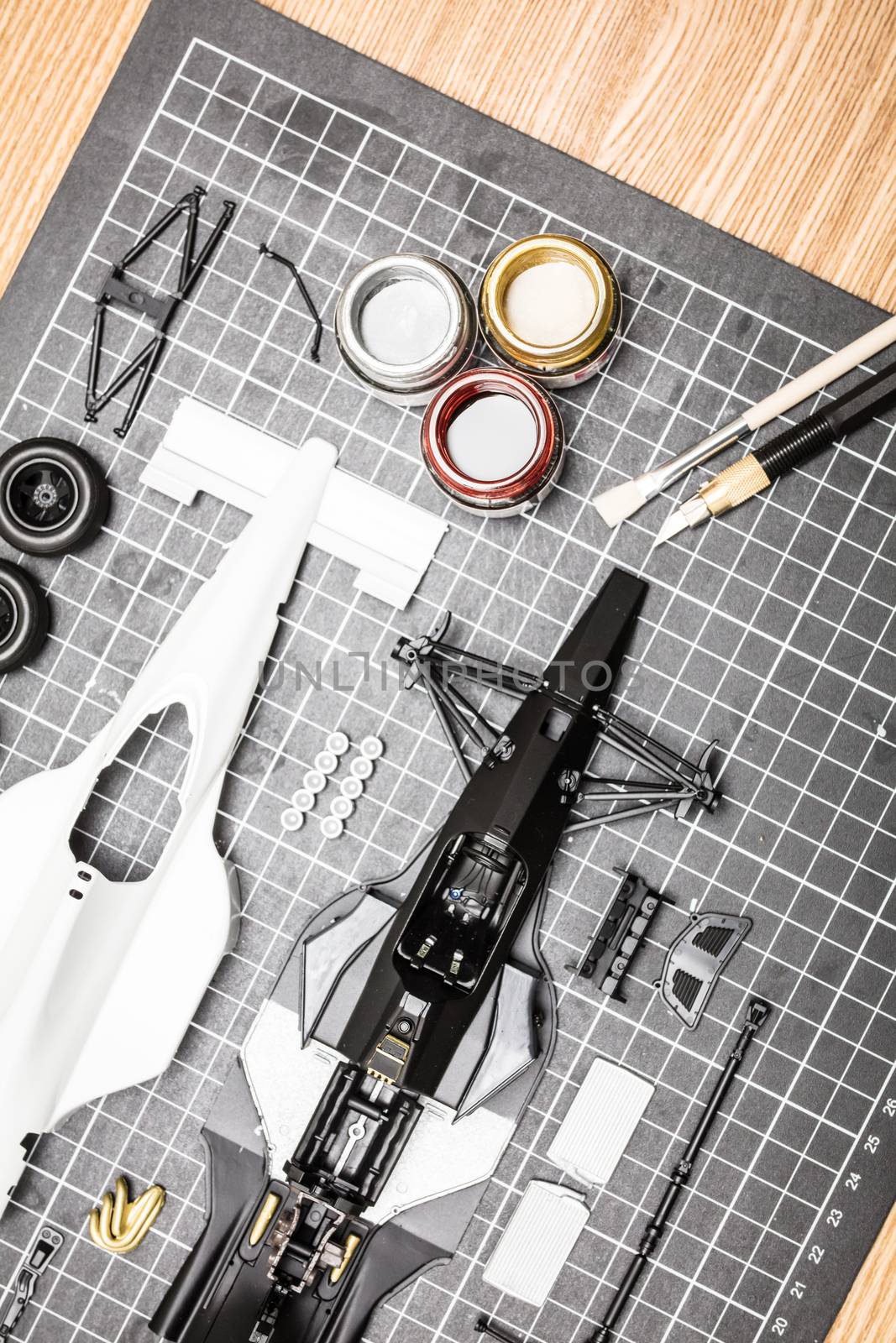 Toy Model Car Parts On A Desk by FiledIMAGE