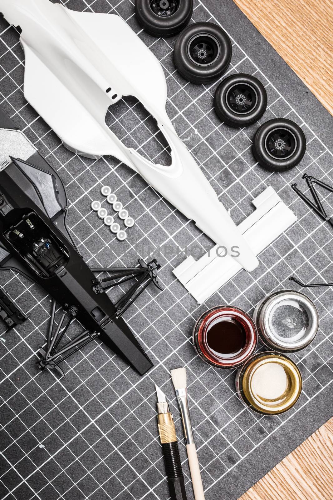 Toy Model Car Parts On A Desk by FiledIMAGE