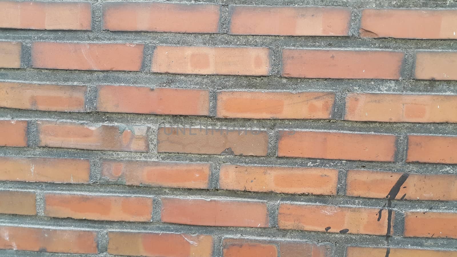 Closeup texture of red brick wall. A background of a weathered old exterior brick wall in the sunshine.