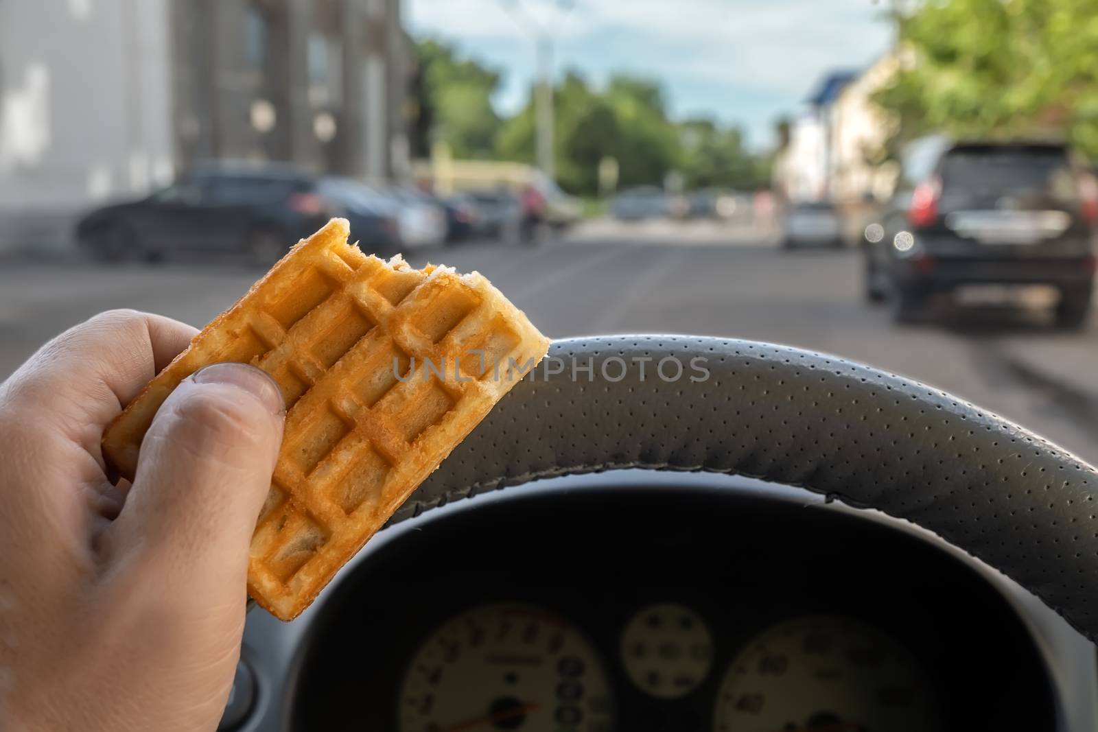 food, cookies in the hand of a car driver while driving in the city