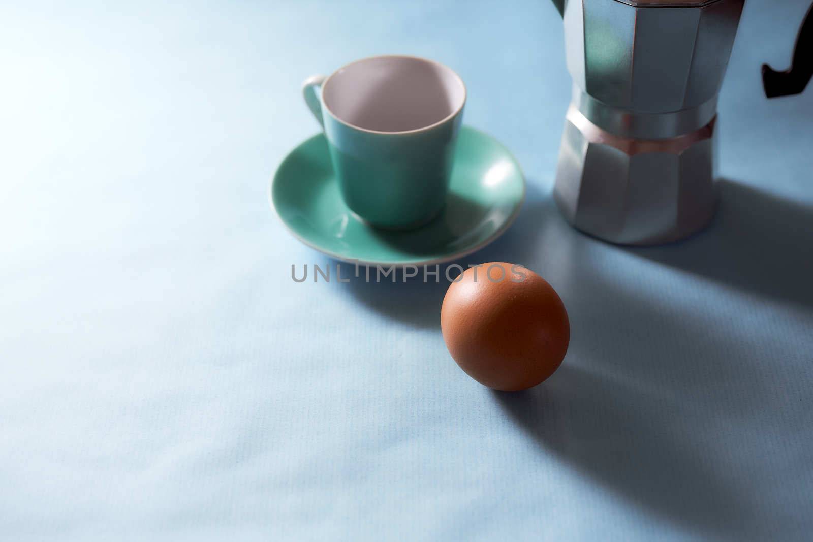 The coffee cup and geyser coffee maker stands on a blue background. With copy space. High quality photo