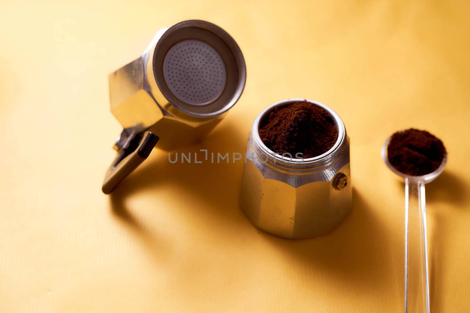 Open geyser coffee maker with fresh coffee on a yellow background. High quality photo