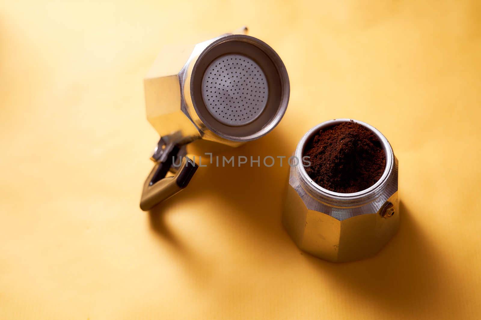 Open geyser coffee maker with fresh coffee on a yellow background. High quality photo