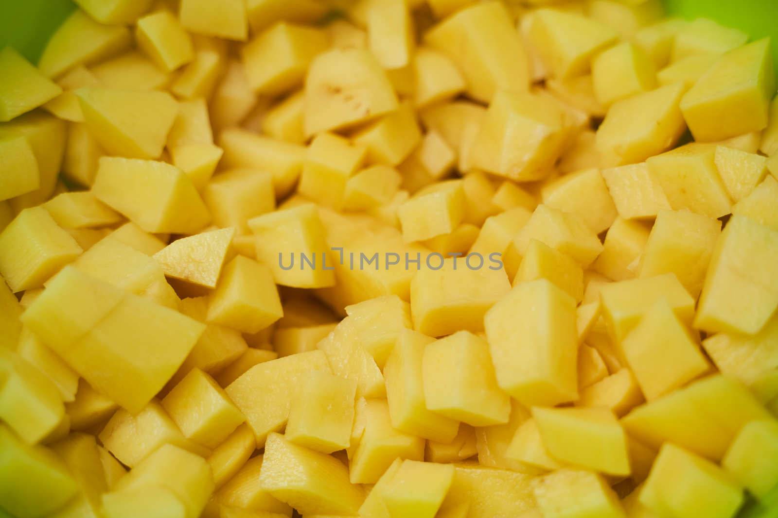 Fresh potatoes in pieces in green utensils . High quality photo