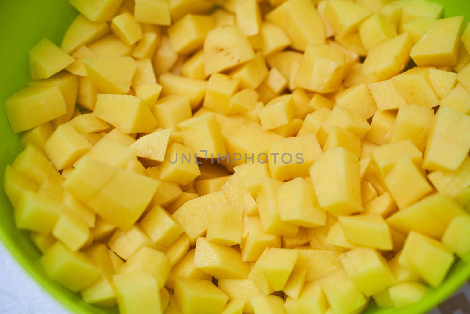 Fresh potatoes in pieces in green utensils . High quality photo