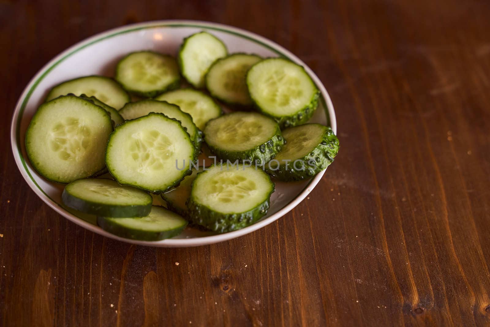 Fresh cucumbers lie in white saucers on a brown background. High quality photo