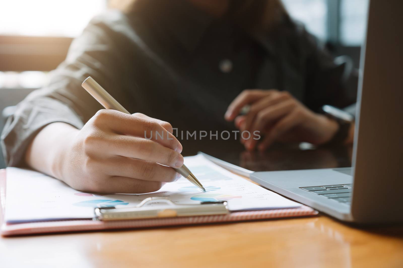 Businessman pen pointing turnover with graph chart report and use laptop computer for analysis data.