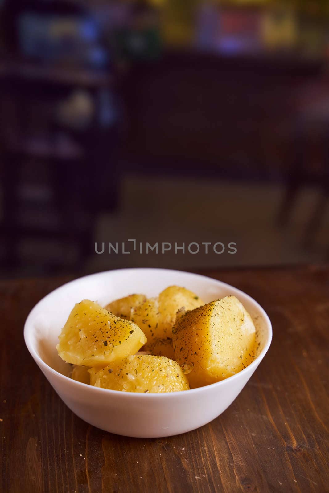 Boiled potatoes with mslom seasonings in a plate on a brown background. High quality photo