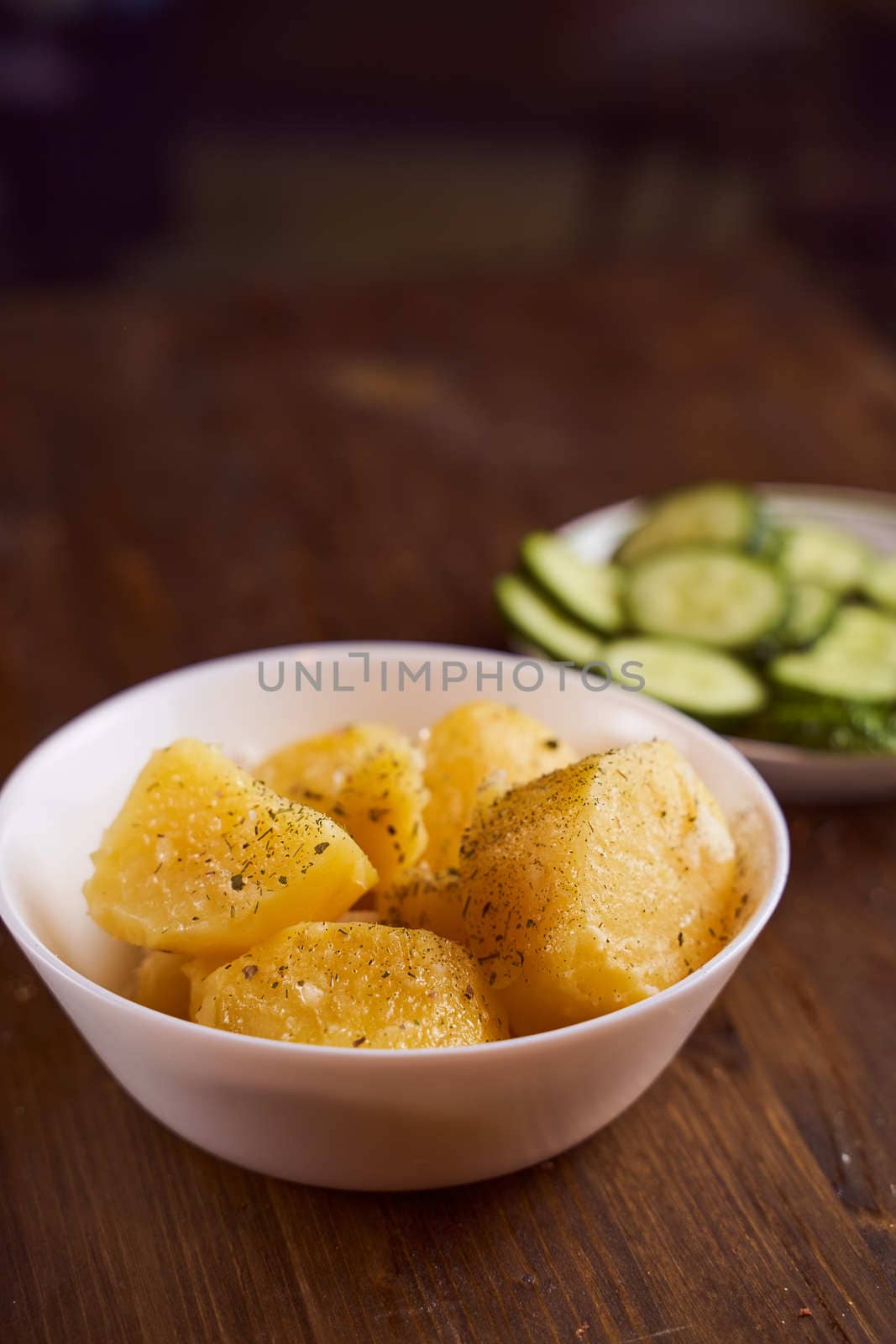 Boiled potatoes with mslom seasonings in a plate on a brown background. High quality photo
