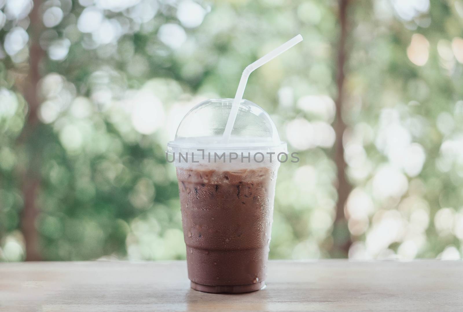 Close up glass of ice chocolate on wood table, selective focus