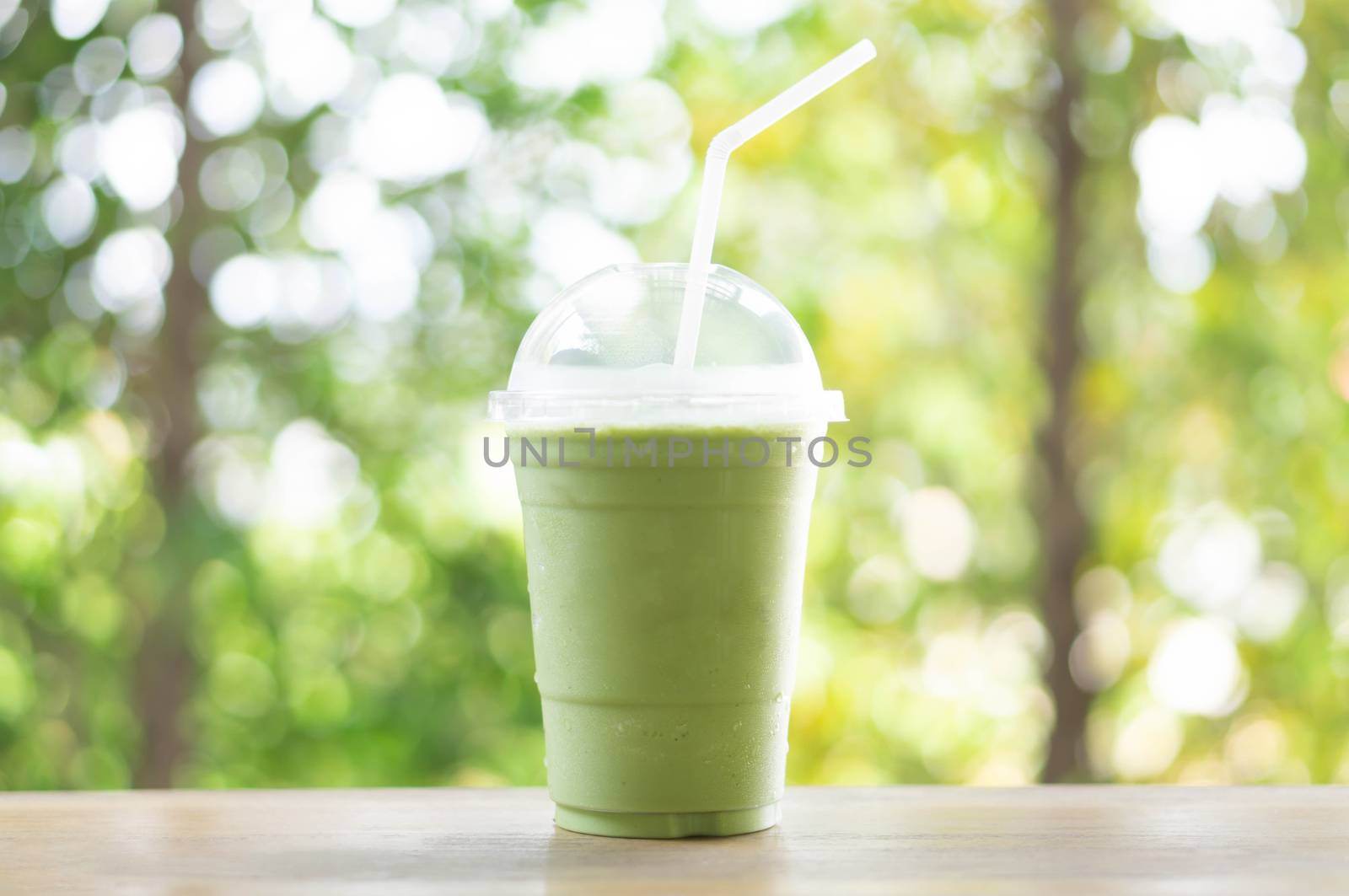 Close up glass of ice matcha green tea on wood table, selective focus