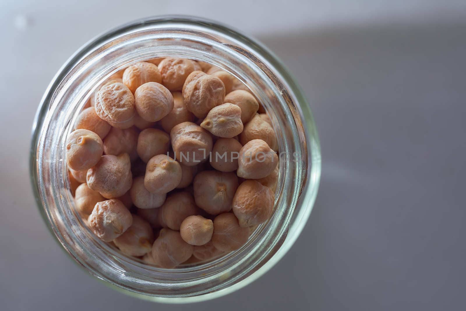 Superfood chickpeas lie in a glass jar. High quality photo