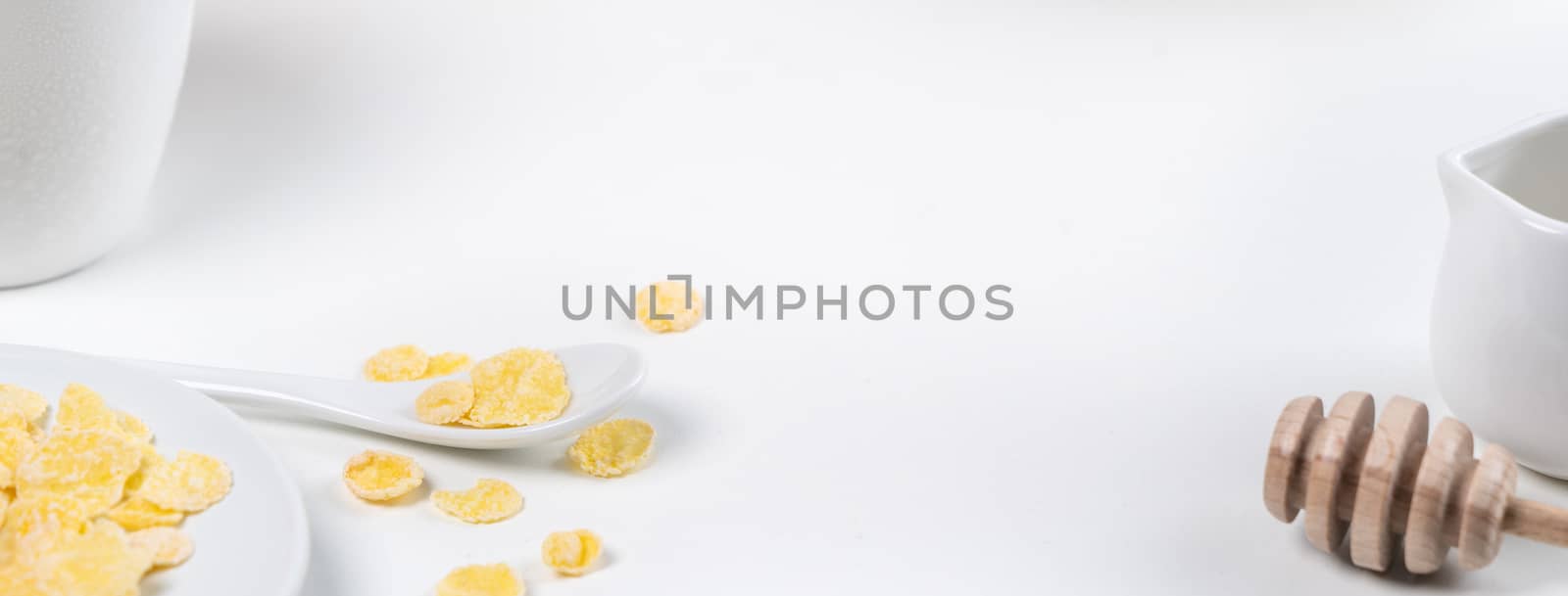 Corn flakes bowl sweeties with milk and orange on white background, close up, fresh and healthy breakfast design concept.