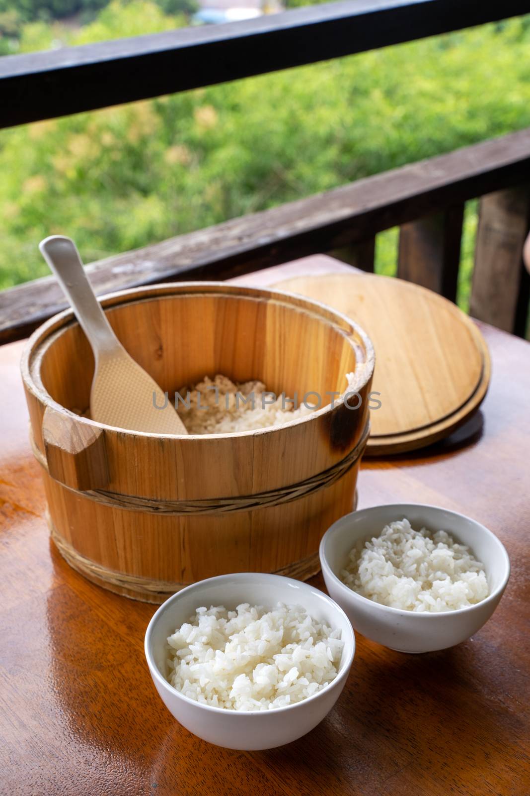 Delicious cooked plain rice in a big wooden bowl ready-to-eat wi by ROMIXIMAGE