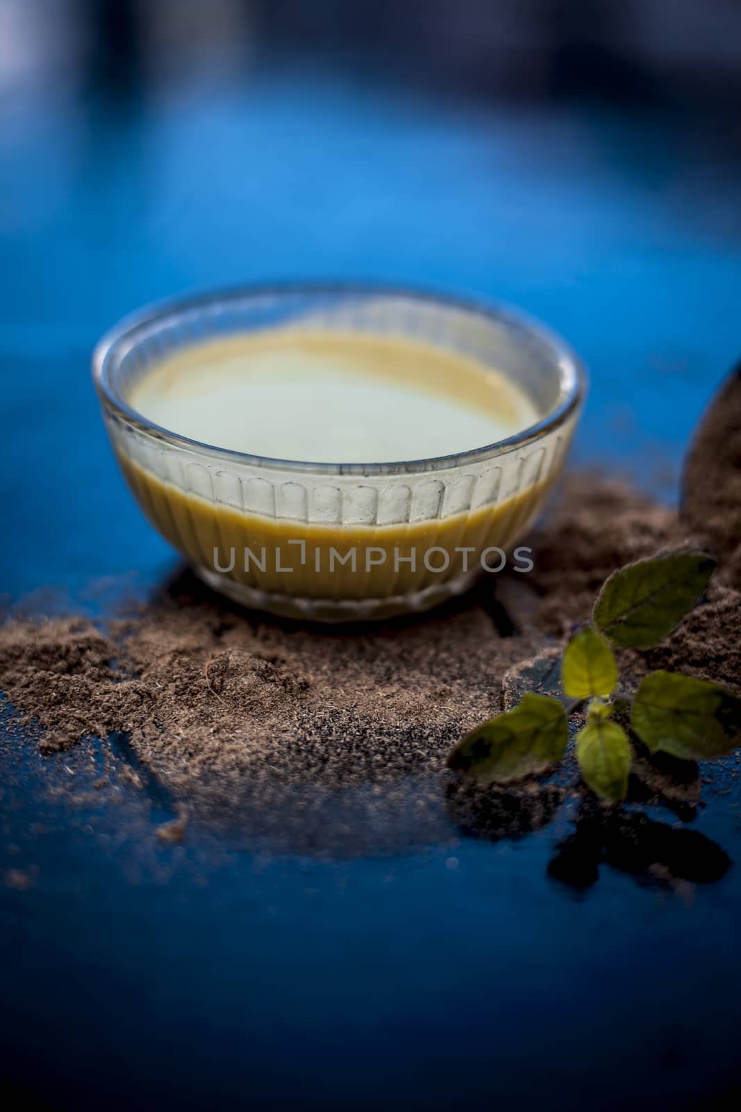 Ayurvedic herb brahmi or Waterhyssop with its beneficial paste ina glass bowl along with its powder on wooden surface.