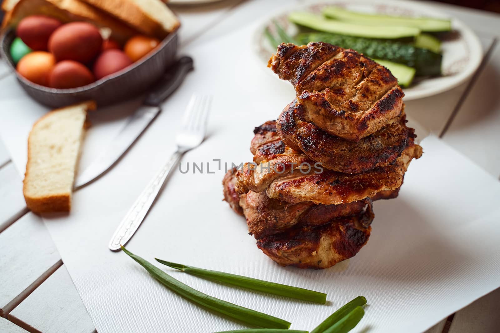 Ready pork steak in a white plate with green onions on a white plate. With copy space. High quality photo