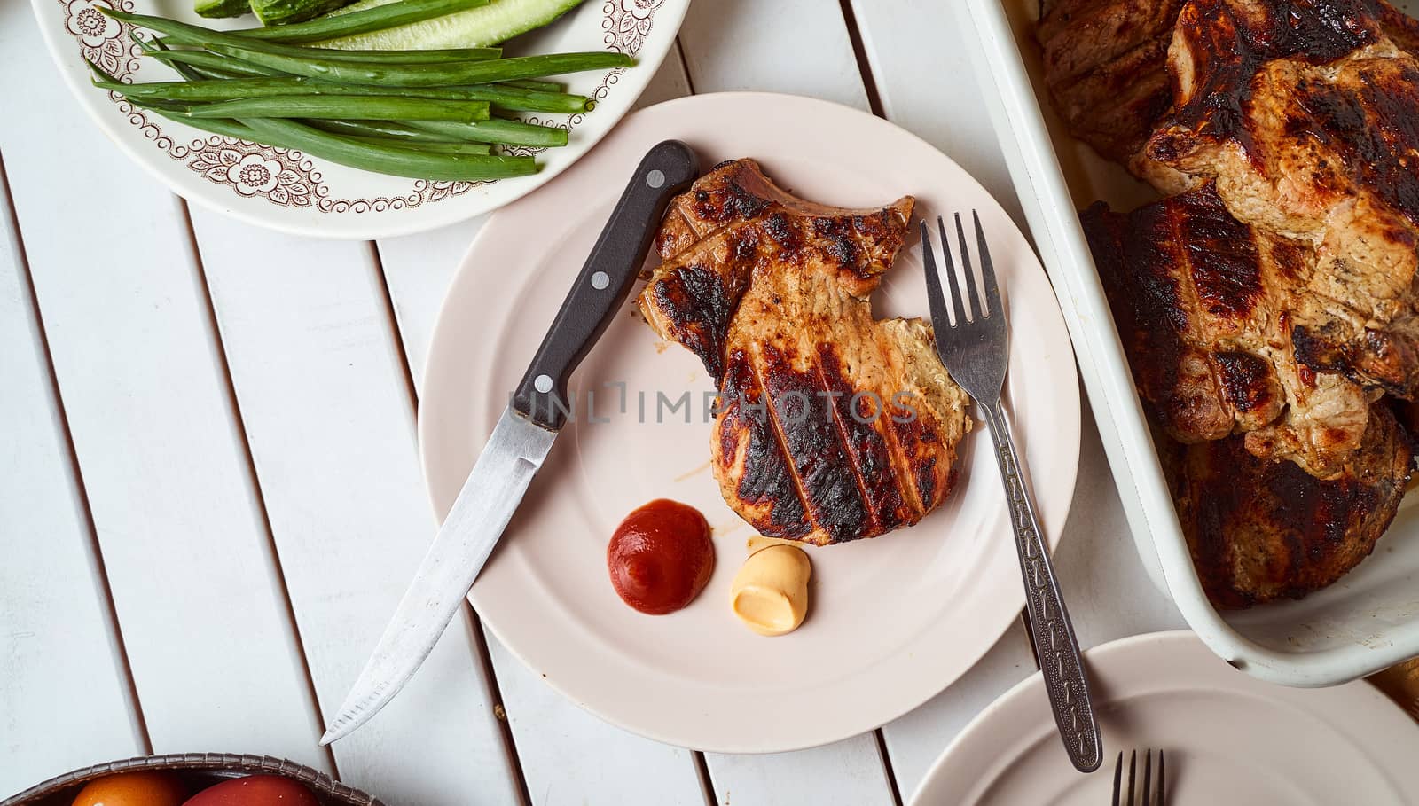 Ready pork steak in a white plate with green onions on a white plate. With copy space. High quality photo