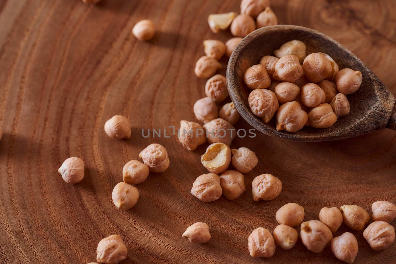 Superfood chickpeas lie in wooden background with spoon. Close-up. Top view. High quality photo